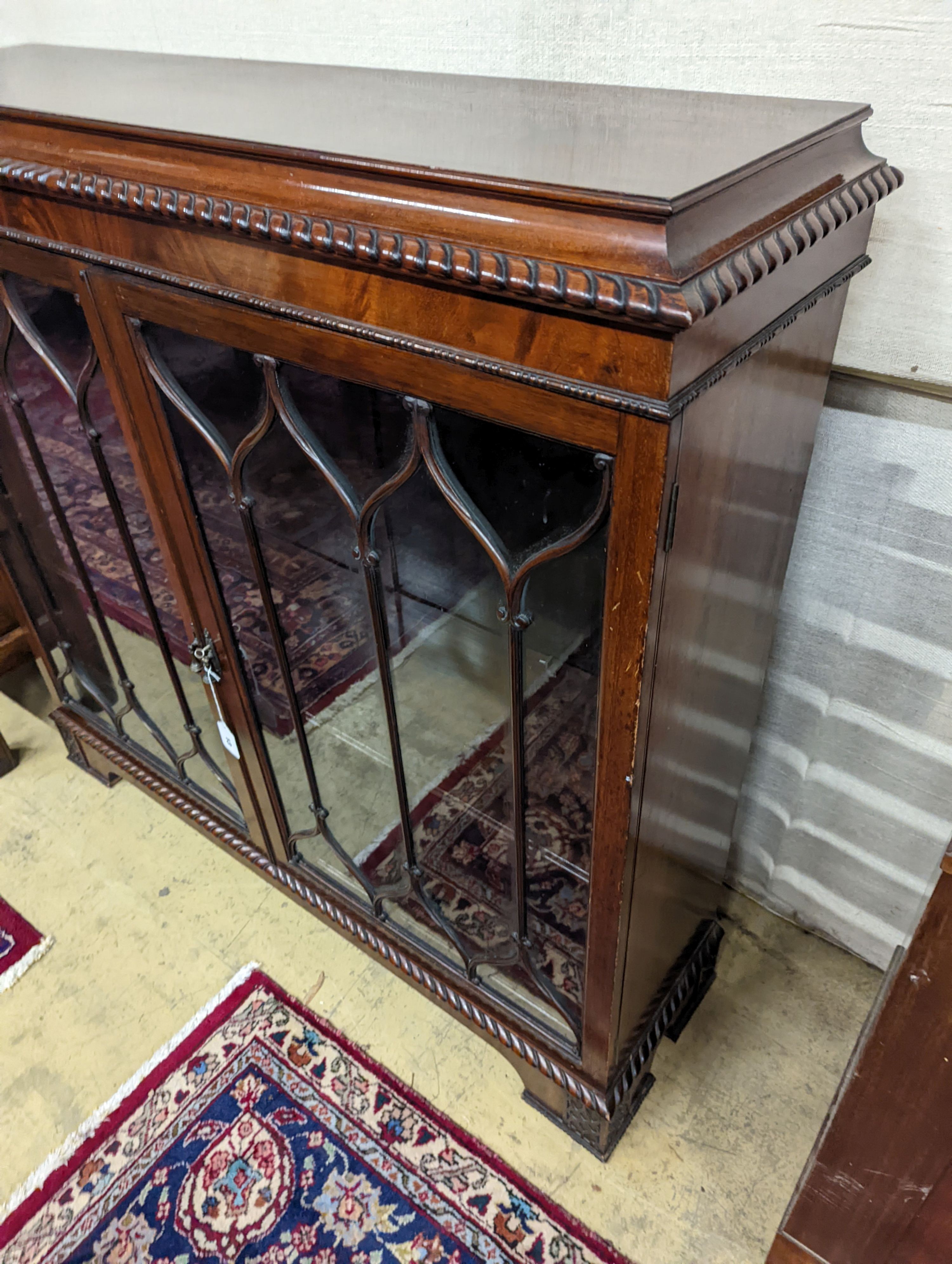 A 1920s mahogany low bookcase, in Chippendale style W-118cm, D-34cm, H-112cm.